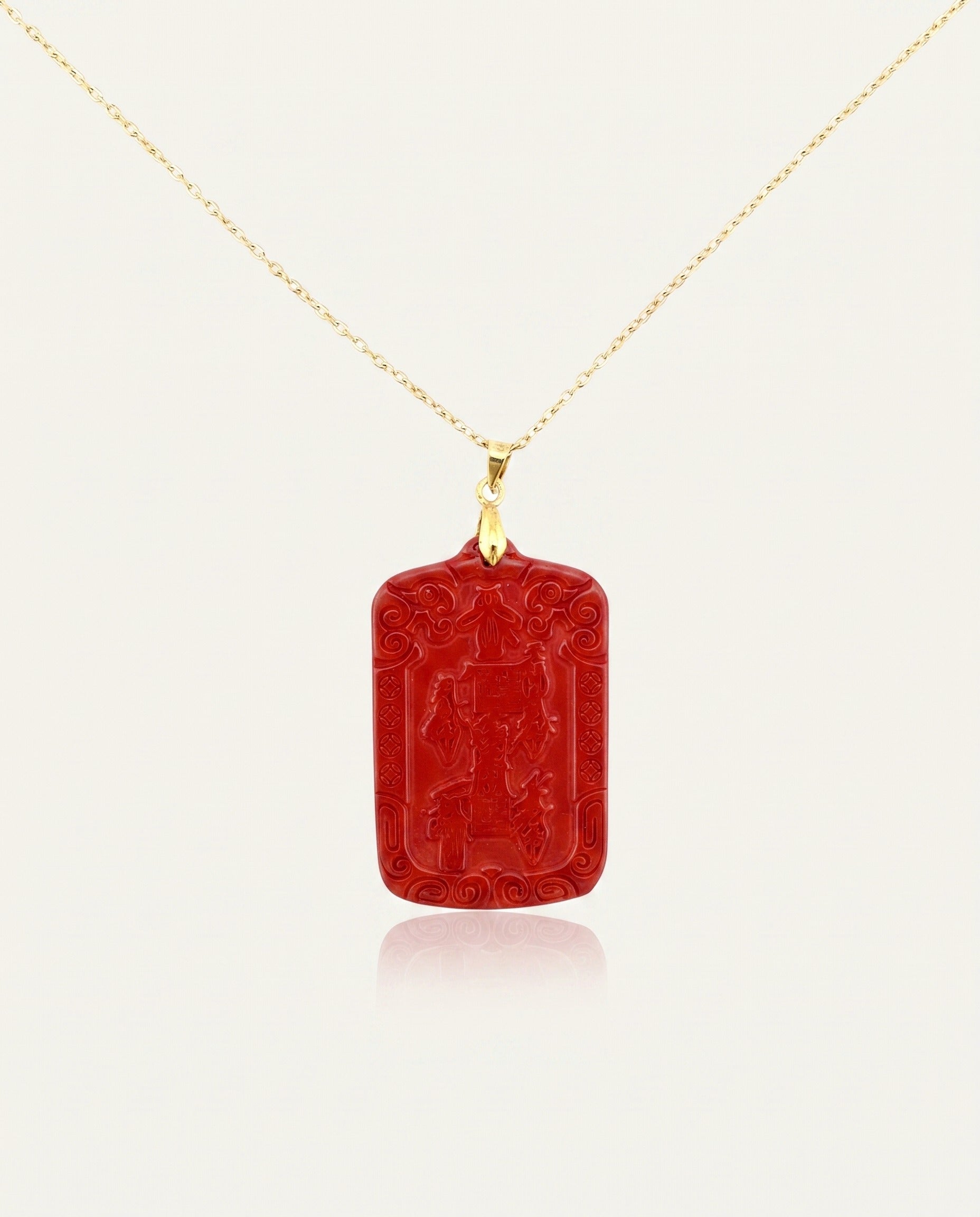 Wealth Talisman cinnabar necklace on gold chain front, ivory studio background