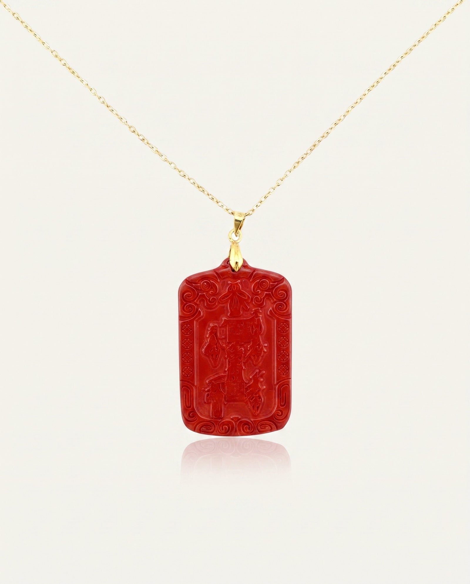 Wealth Talisman cinnabar necklace on gold chain front, ivory studio background