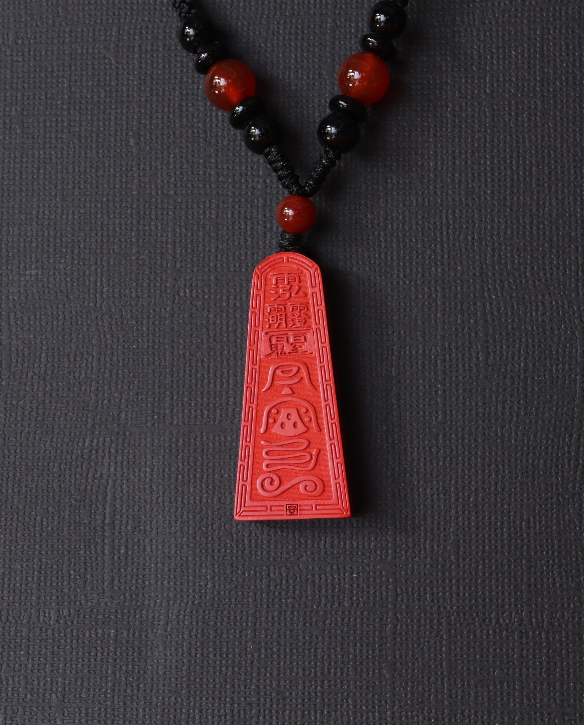 Wealth Talisman Trapezoid cinnabar necklace on dark background