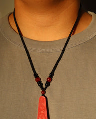 Wealth Talisman Trapezoid cinnabar necklace on dark background