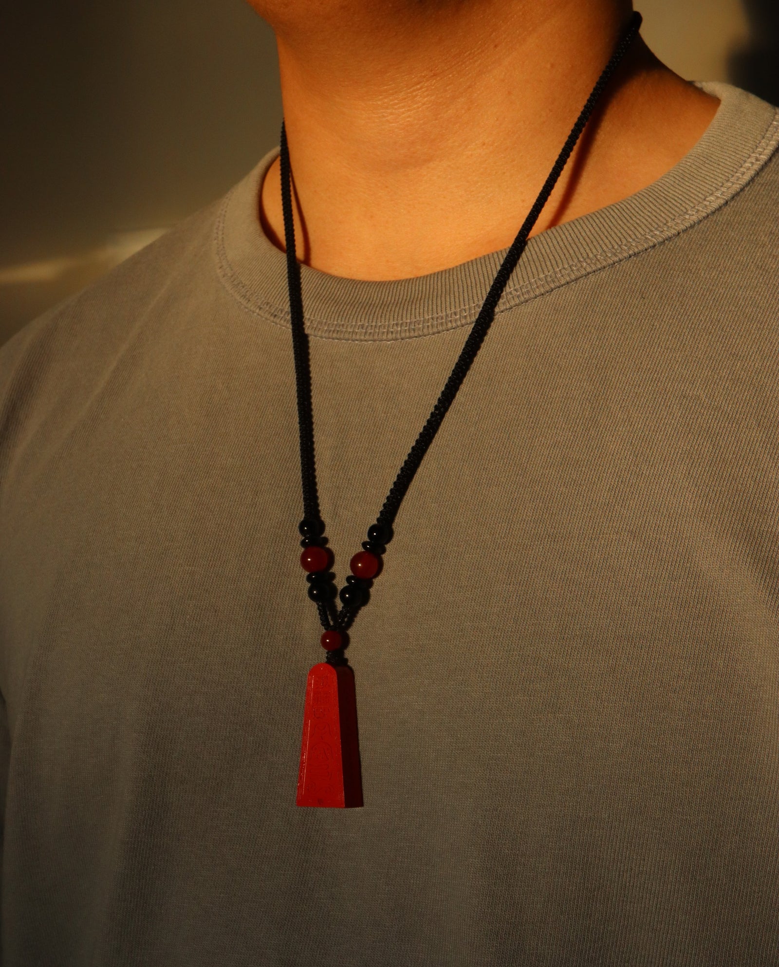 Wealth Talisman Trapezoid cinnabar necklace on dark background