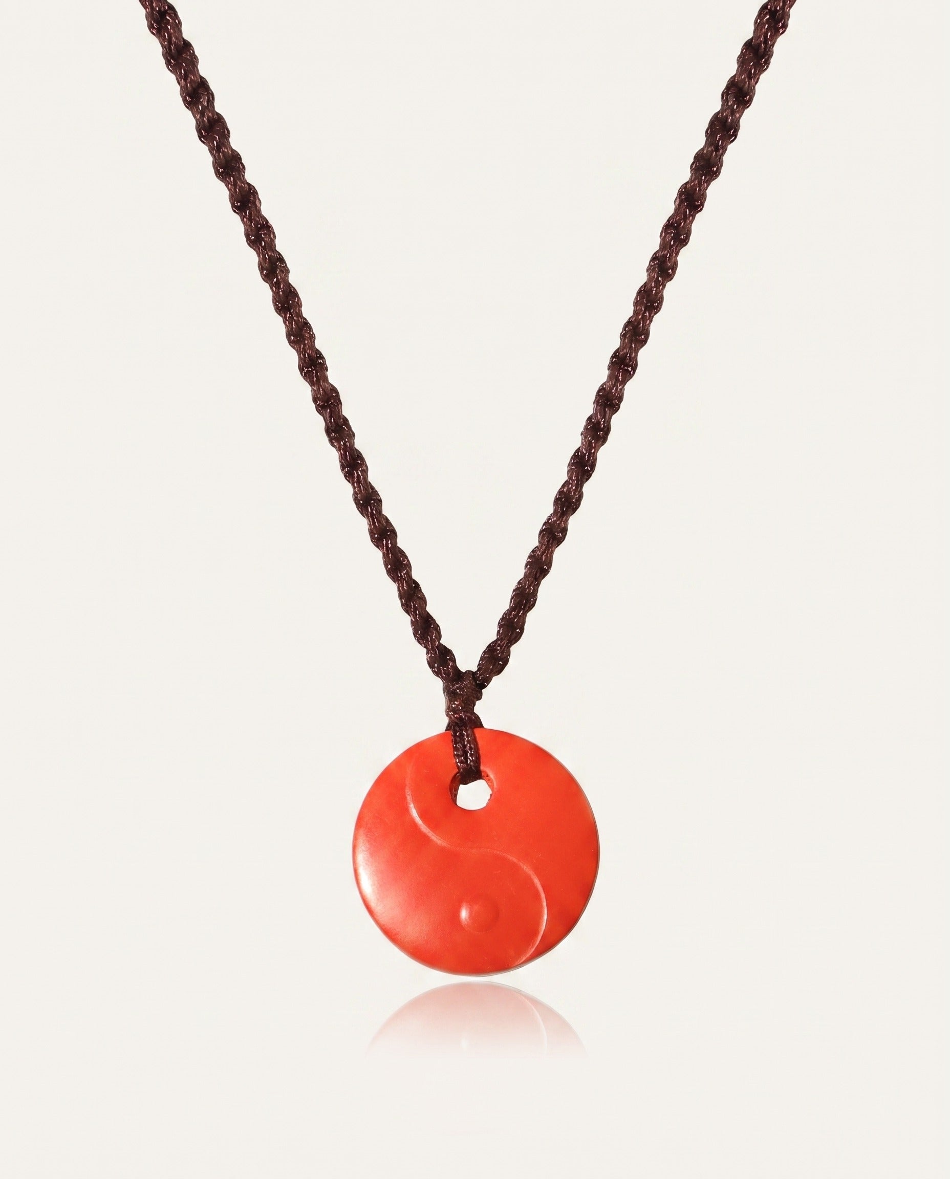 Yin Yang cinnabar necklace on ivory studio background