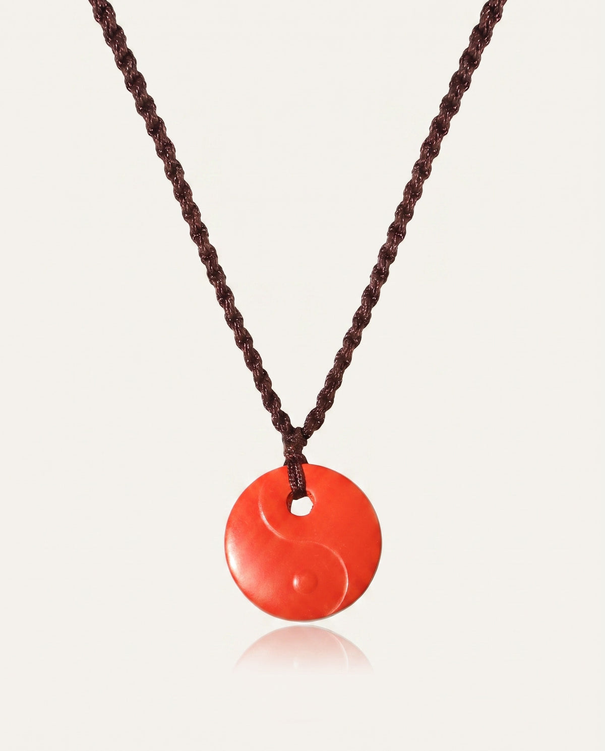 Yin Yang cinnabar necklace on ivory studio background